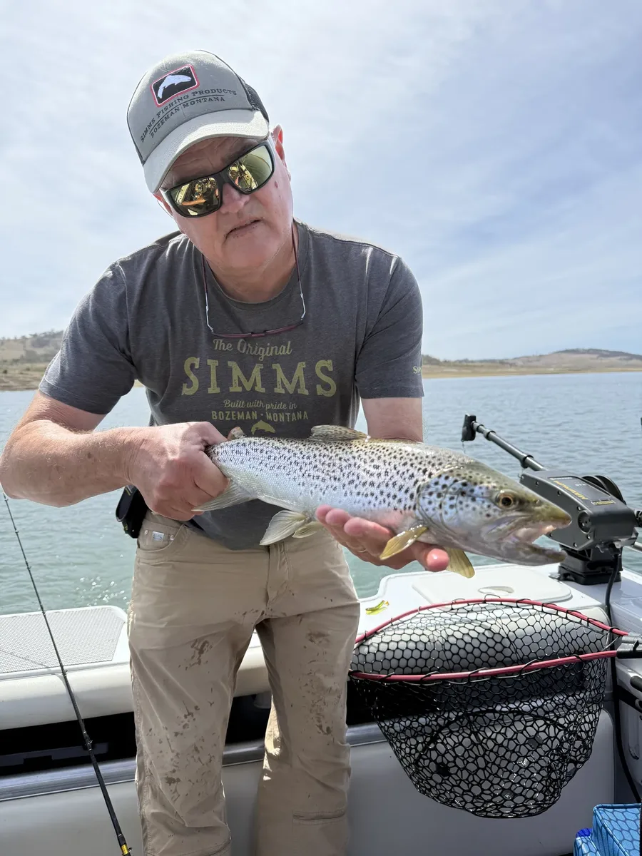 Mick Couvee, trout fishing guide, with a brown trout